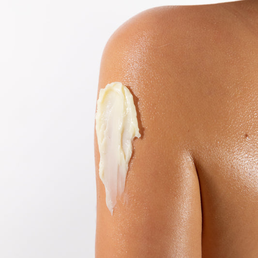 Creamy body butter applied to a shoulder, highlighting smooth skin texture.