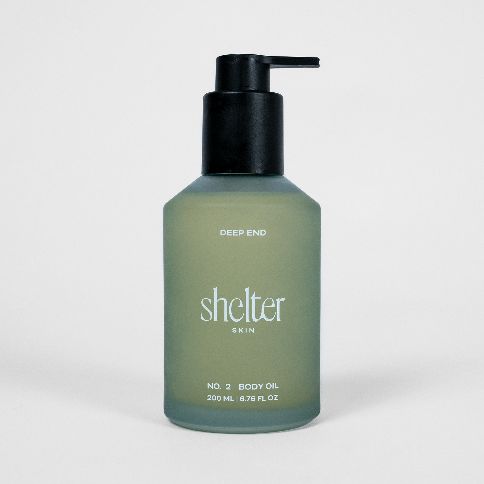 Bottle of 'shelter skin' body oil on a white background