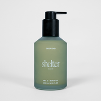 Bottle of 'shelter skin' body oil on a white background
