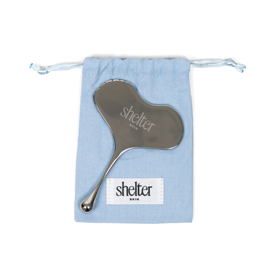 Contouring Stainless Steel Gua Sha with blue pouch, designed for facial massage and skincare.
