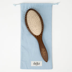 Tools Bundle featuring a wooden hairbrush with a light blue storage pouch.