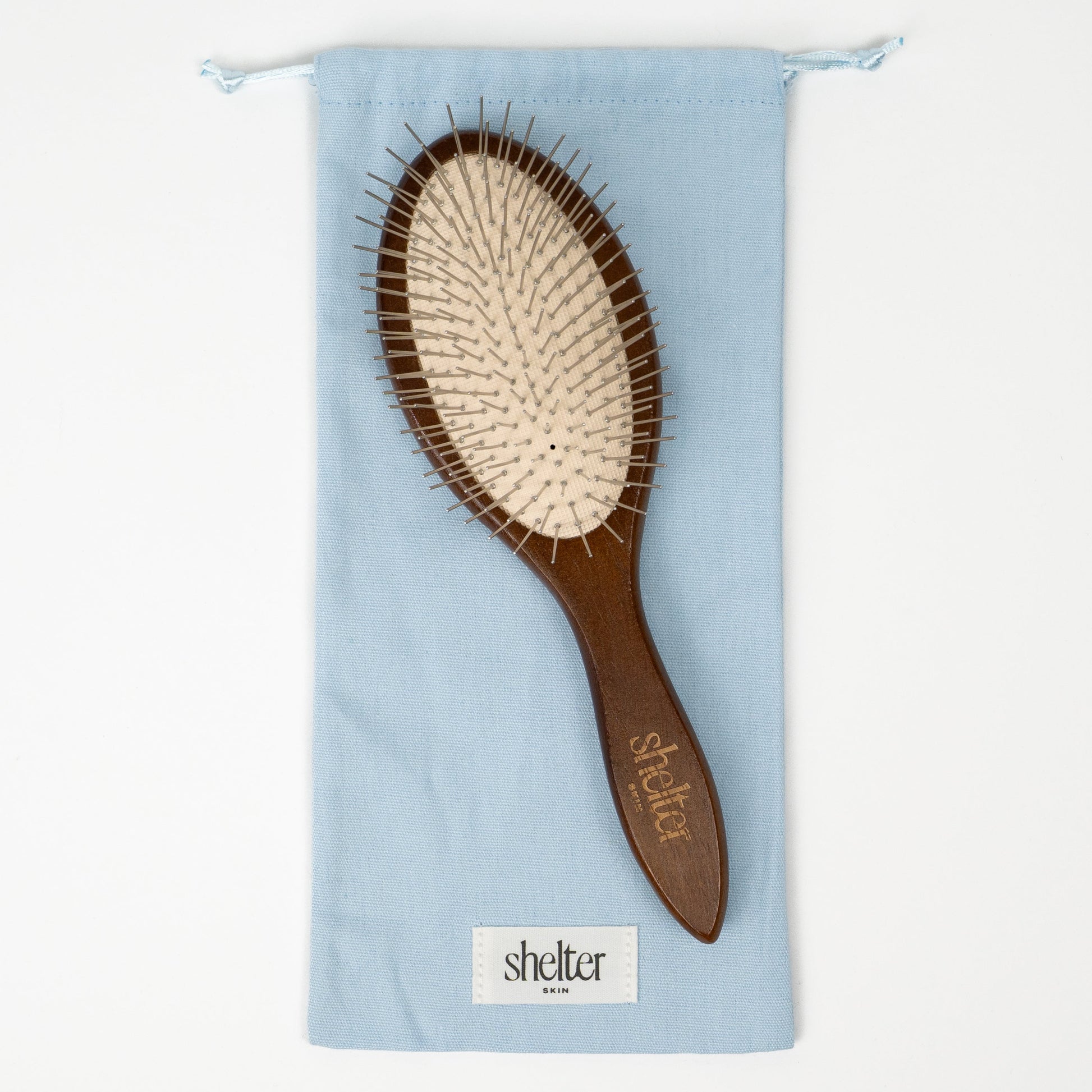 Tools Bundle featuring a wooden hairbrush with a light blue storage pouch.
