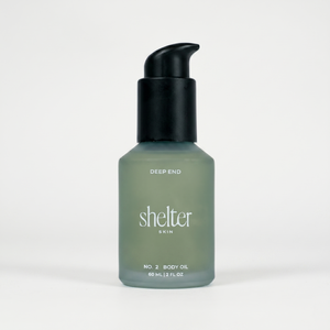 Bottle of 'Shelter Skin' body oil on a white background